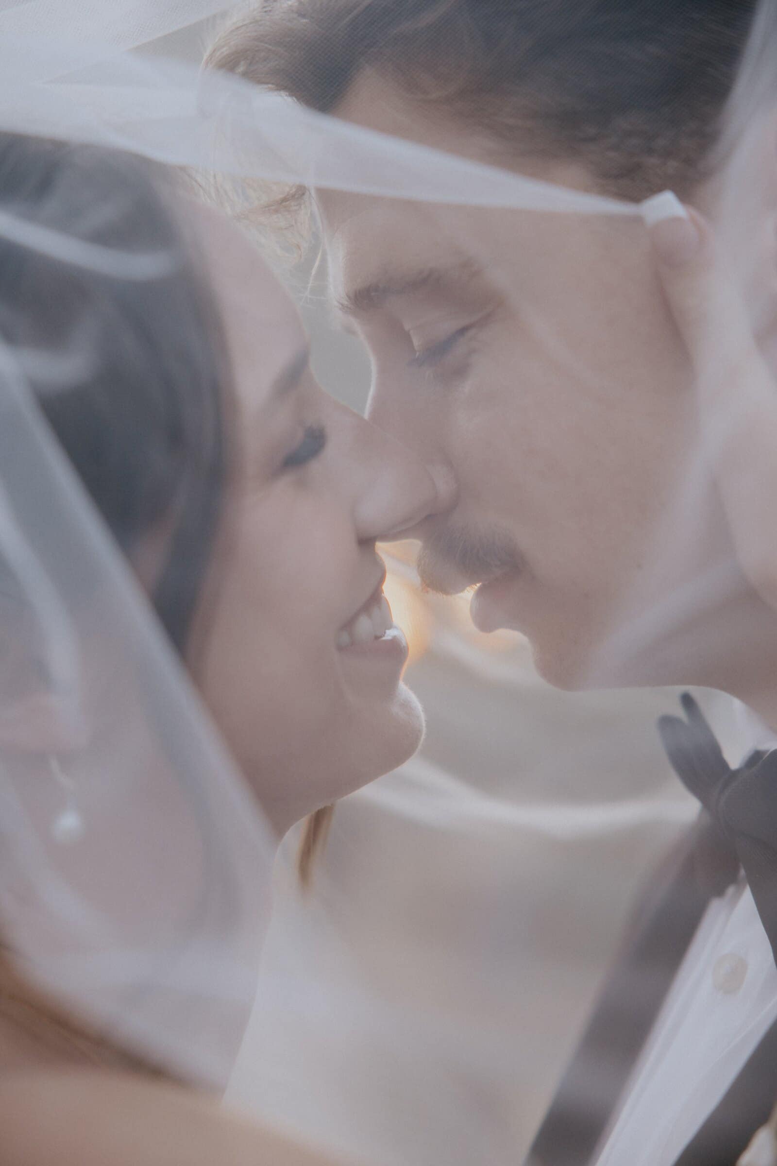 Clara and Grant nose to nose beneath her veil