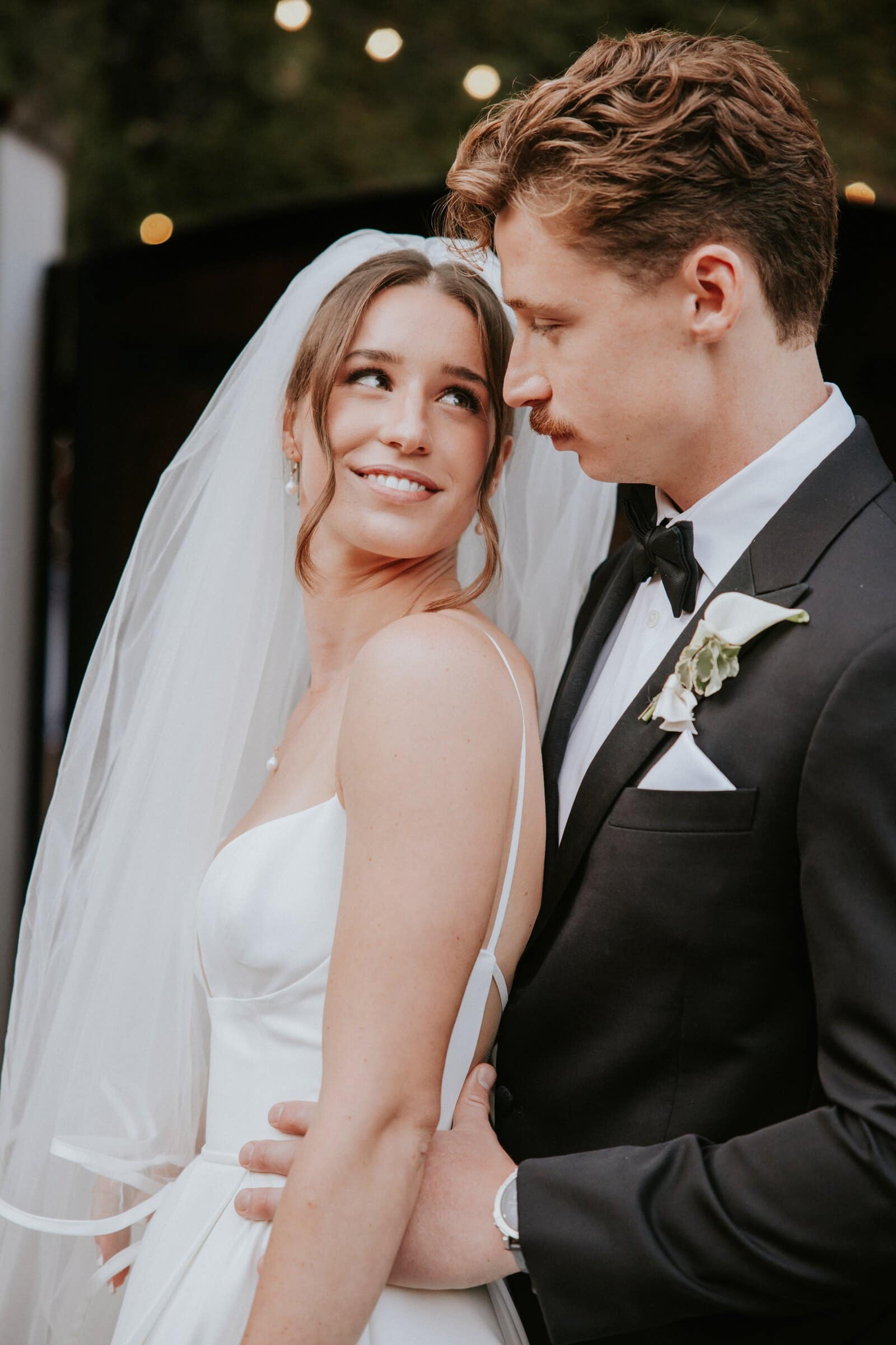 Clara smiling under her veil as Grant leans his head against hers