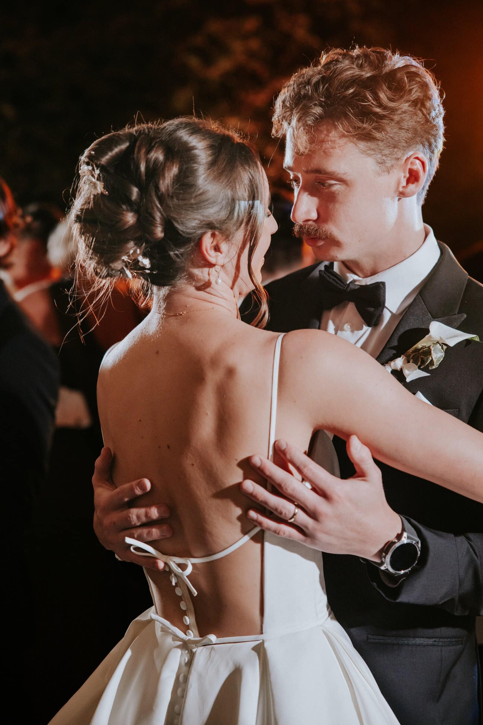 Clara and Grant slow dancing, his hands on the open back of her gown